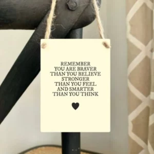 Cream mini metal sign with the words “Remember you are braver than you believe, stronger than you feel and smarter than you think,” finished with a small black heart and jute string hanger.