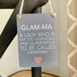 Mini metal sign with the words “Glam-Ma – A lady who is far too gorgeous and glamorous to be called Grandma,” hanging by a jute string.