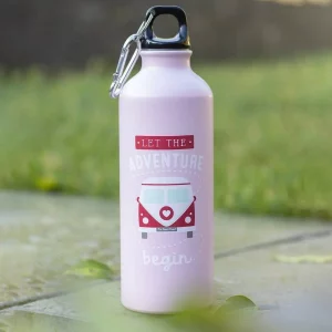 Let the Adventure Begin pink campervan water bottle photographed outdoors on stone ground with green grass in the background.