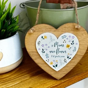Wooden heart-shaped hanging sign with a smaller white floral heart centre reading “If Mums were flowers, I’d pick you”. Displayed on a wooden shelf beside a potted plant and green bucket.
