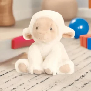 Soft plush lamb toy made from recycled materials sitting on a nursery rug surrounded by colourful toys.