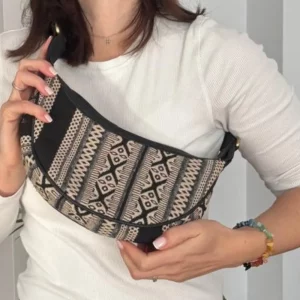Grey woven hobo shoulder bag showing curved shape and black strap
