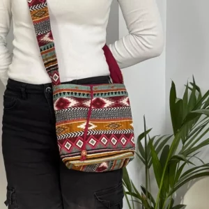 Maroon crossbody sling bag worn on the body showing size and fit