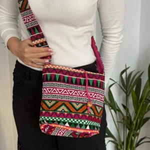 Pink woven sling bag worn crossbody showing size and fit