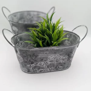 Rustic oval metal planter with floral embossing and side handles