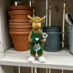 Highland cow ornament wearing green overalls holding shovel
