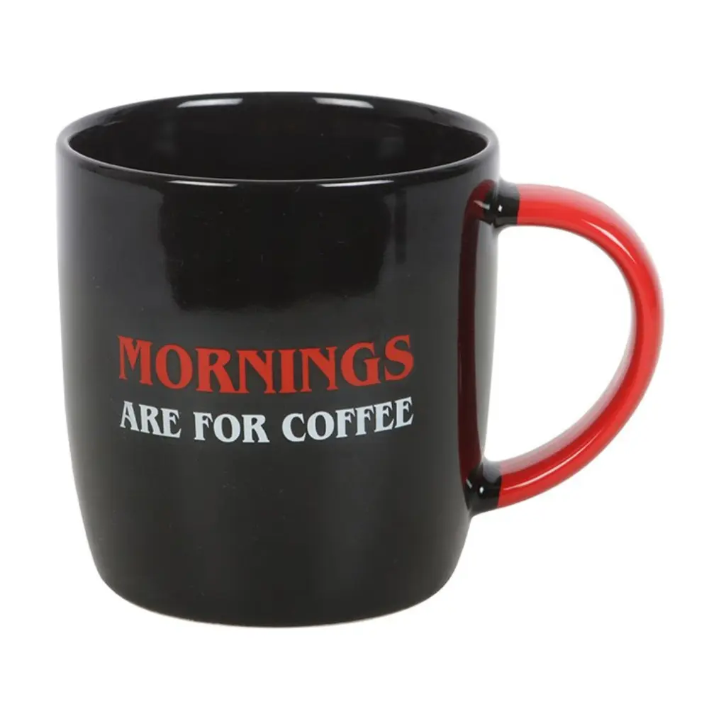 Black ceramic mug with red handle reading “Mornings Are For Coffee”